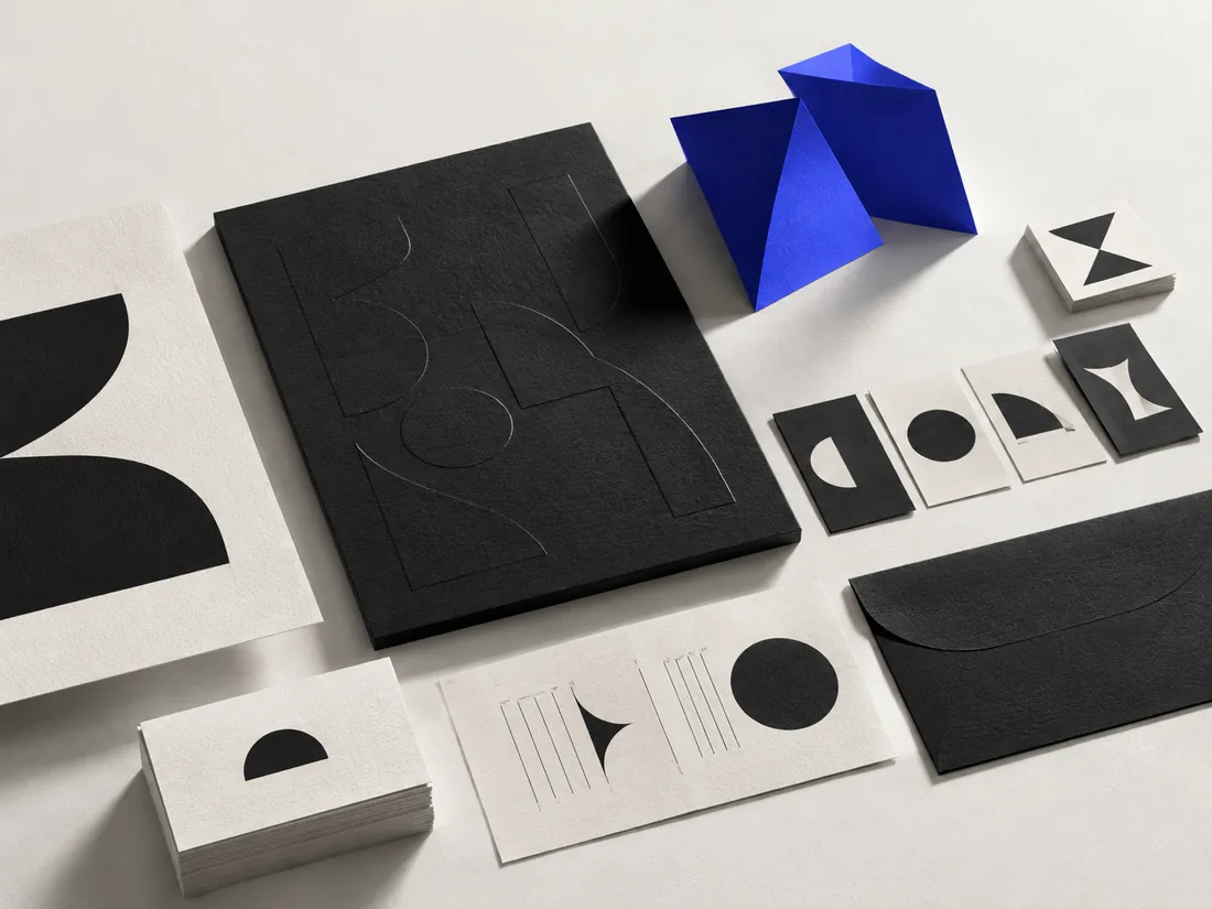 Conceptual studio image of a coordinated visual identity system in paper and cobalt.