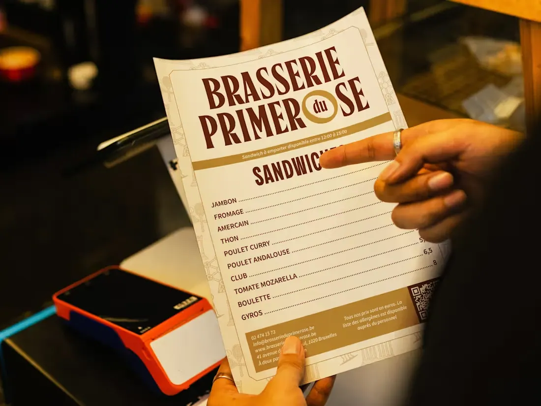 Brasserie du Primerose cream-and-brown menu held at a restaurant counter.