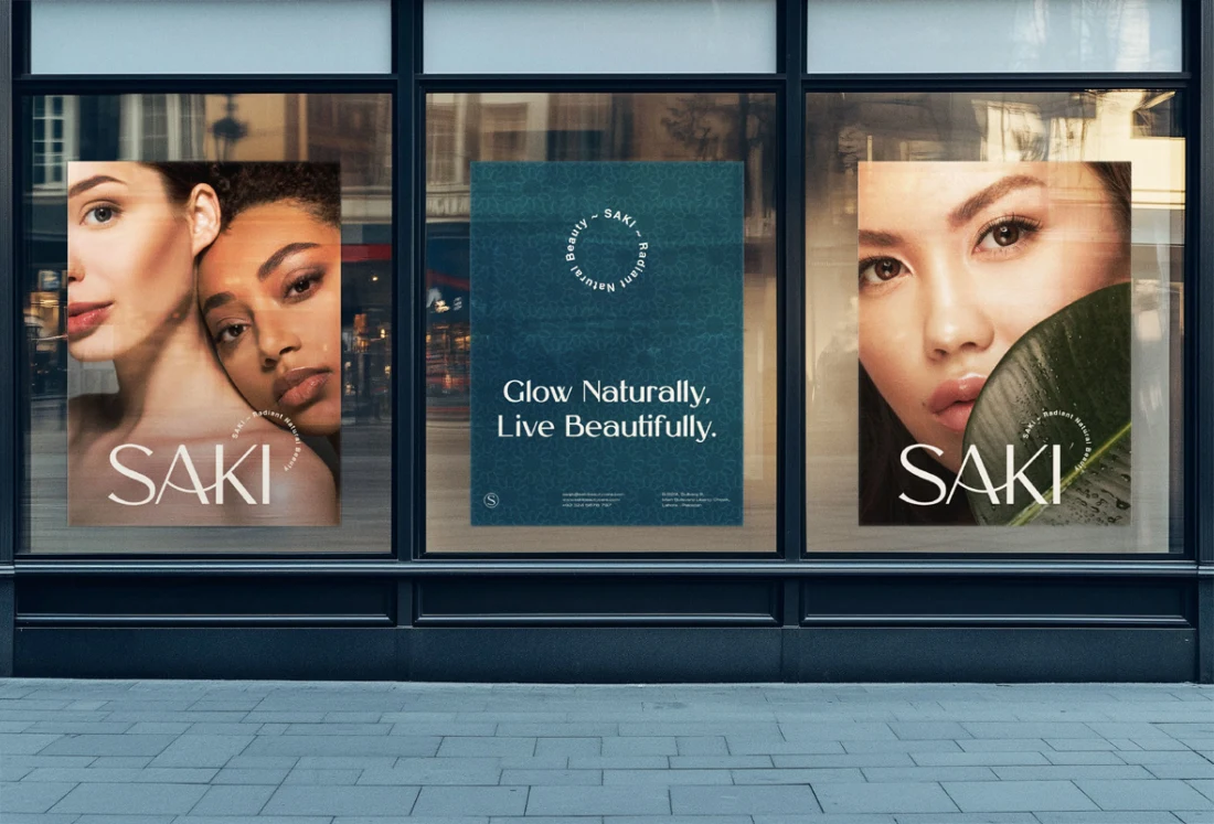 Three SAKI campaign posters displayed in a shop window.